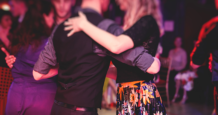 Couples dancing traditional latin argentinian dance milonga in the ballroom, tango salsa bachata lesson in the red lights, dance festival